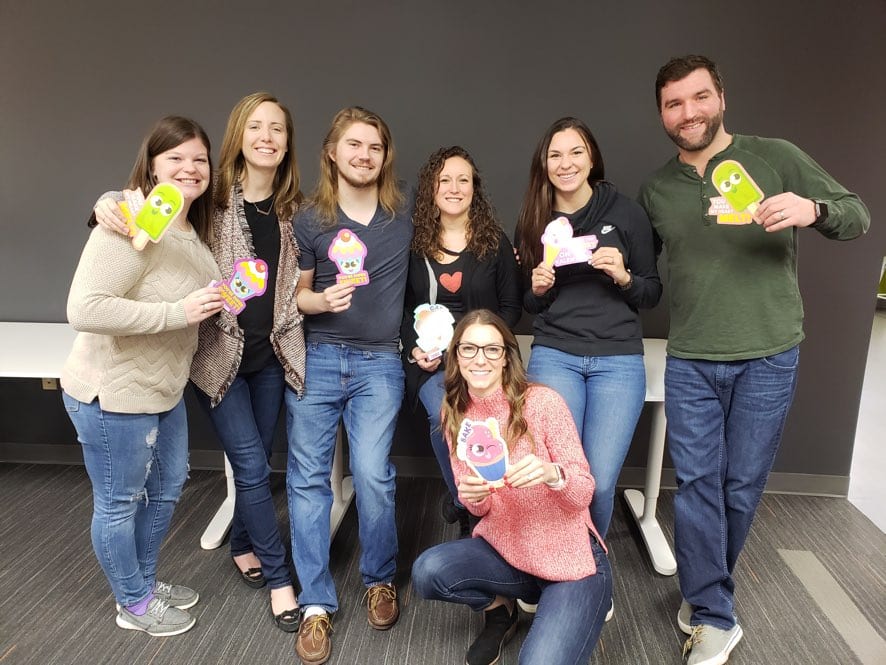 TrackFive team holding playful cupcake and popsicle cards