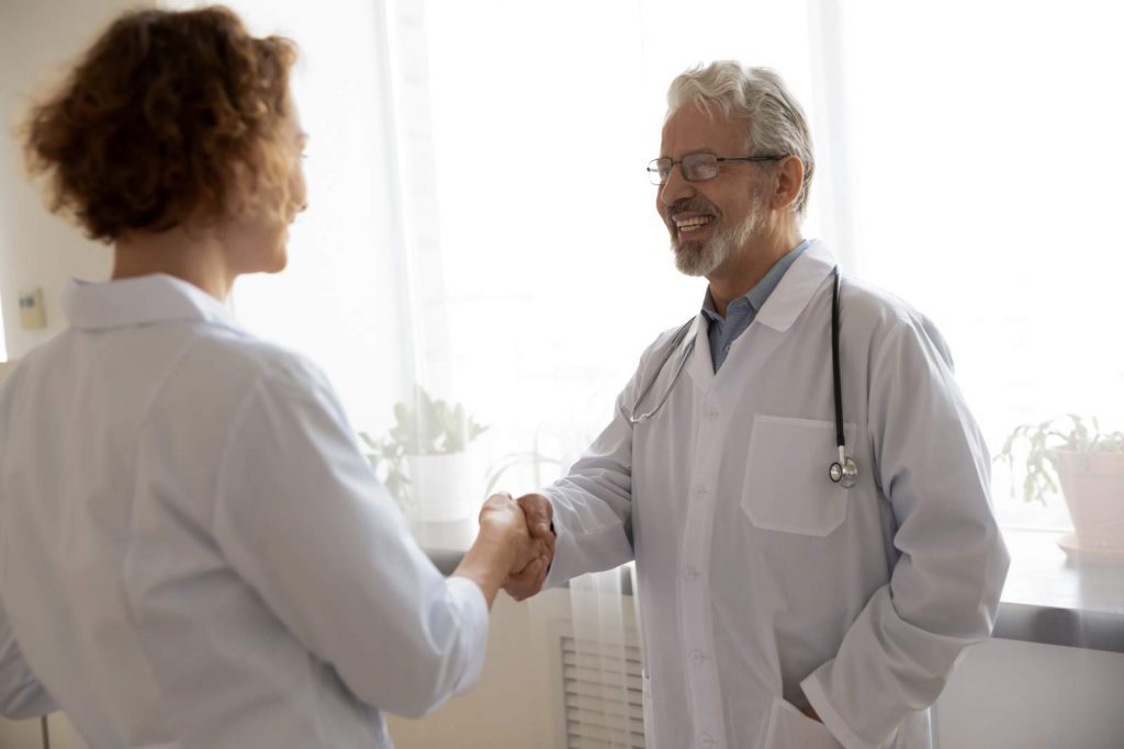 Two healthcare workers shaking hands
