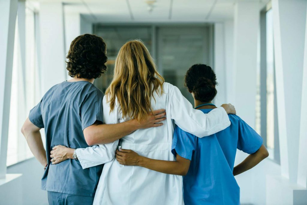 Three healthcare workers hugging