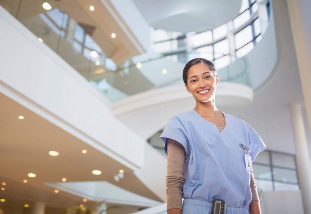 A young nurse standing in a hospital atrium