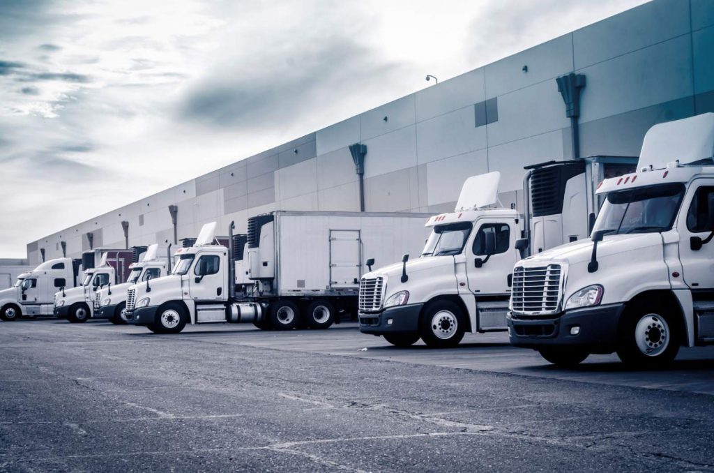 White trucks lined up at a distribution center