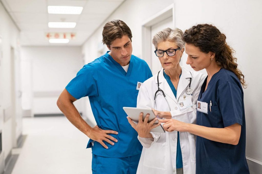 Two nurses consulting with a doctor