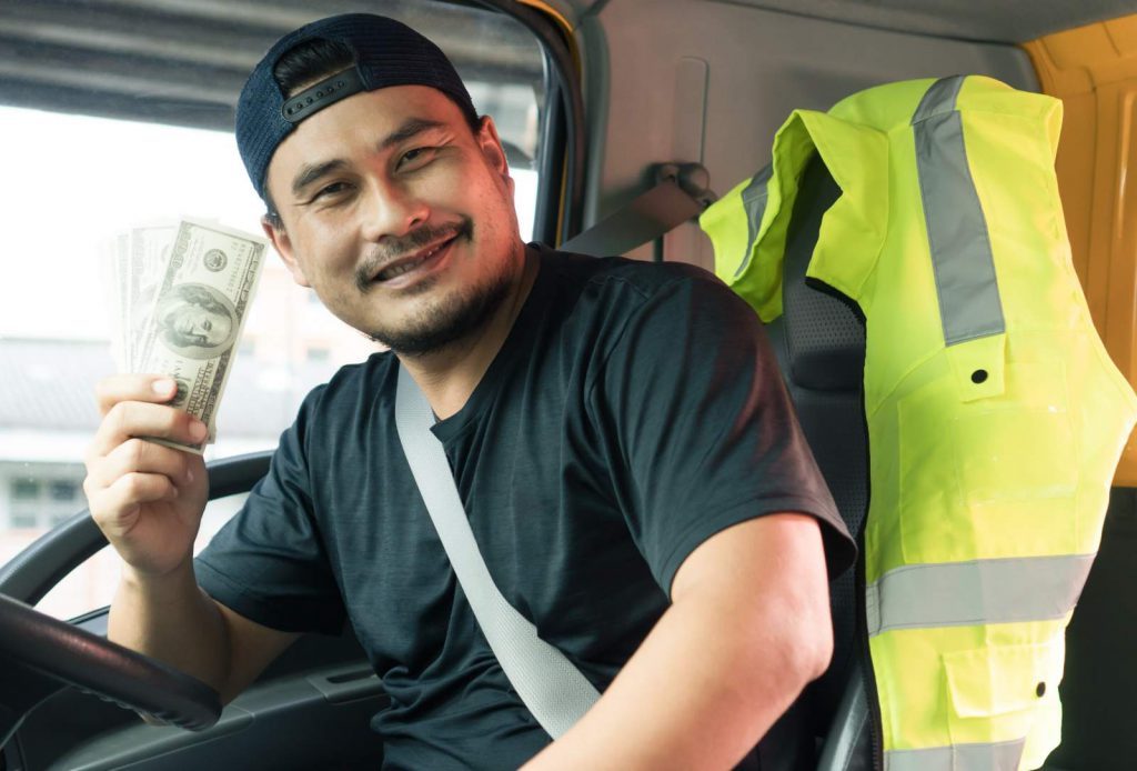 Truck driver holding up money.