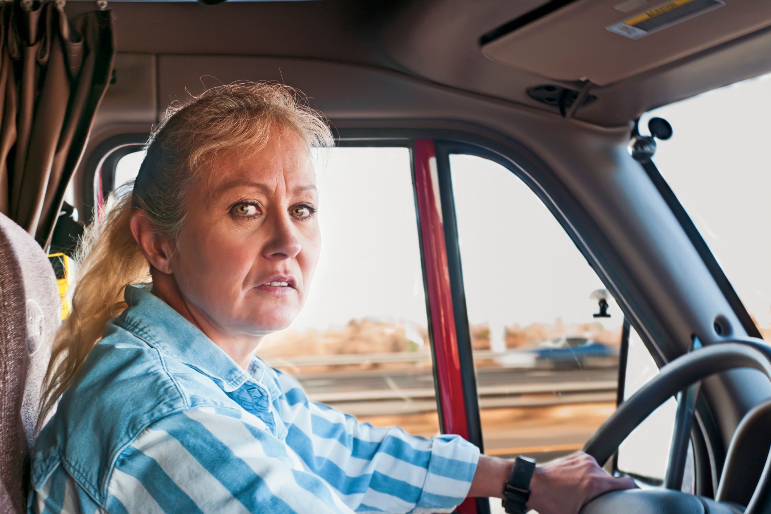A female truck driver looking into the camera
