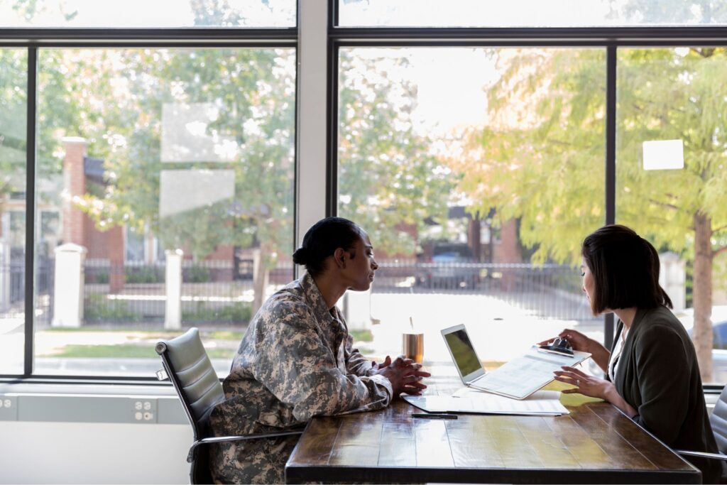 A female veteran talking to a lady at a desk