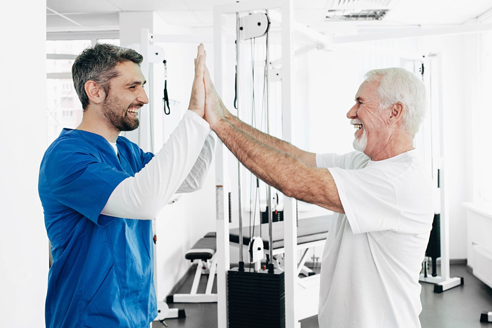 A male physical therapist high-fiving his patient