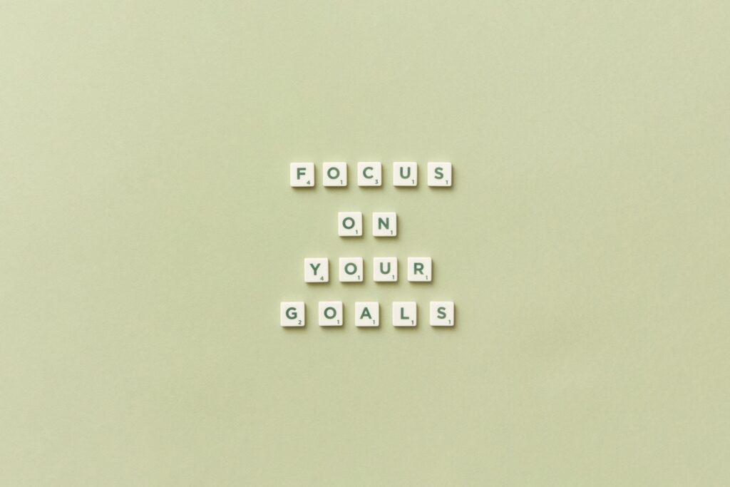 Scrabble letters on a green background reading "focus on your goals" 