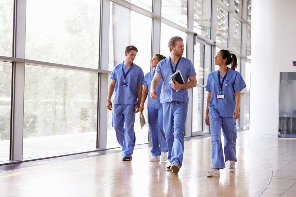 A group of healthcare workers walking and talking in a hospital corridor