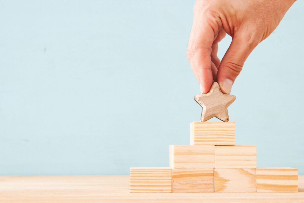 A person holding a gold star on top of blocks