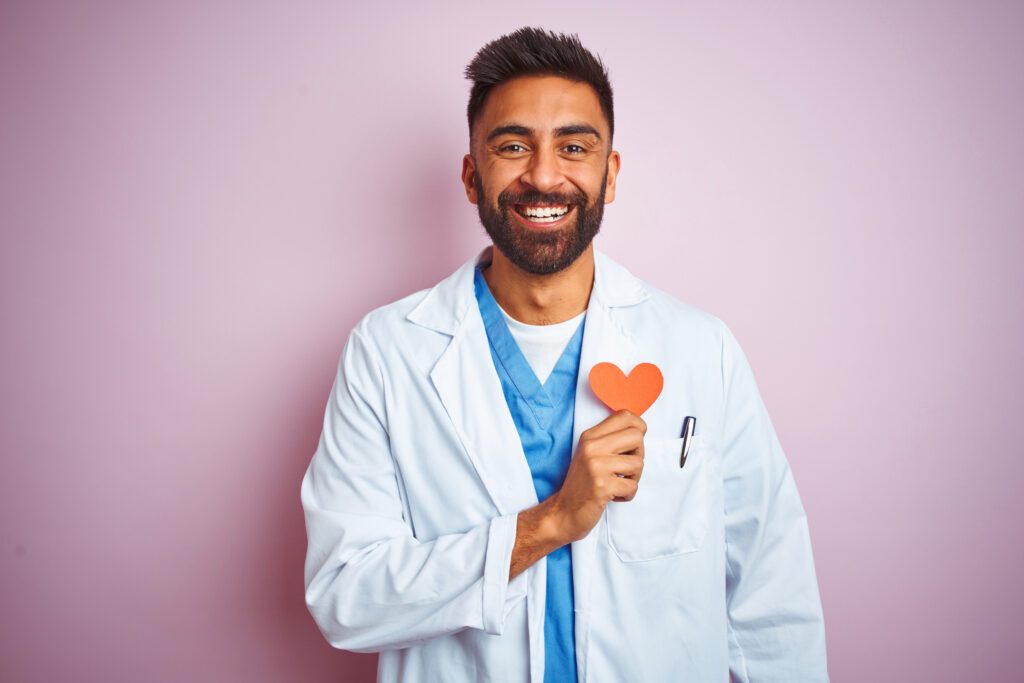 Doctor smiling and holding a paper heart
