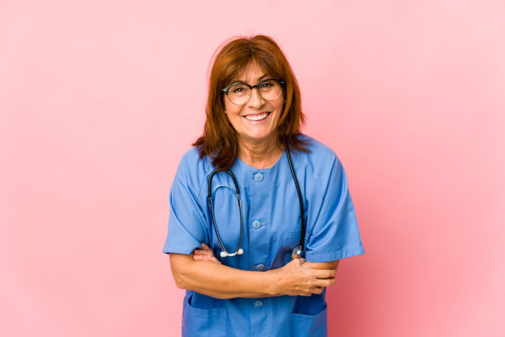 Nurse smiling at camera with a pink background