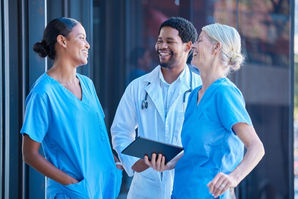Two nurses laughing with a doctor