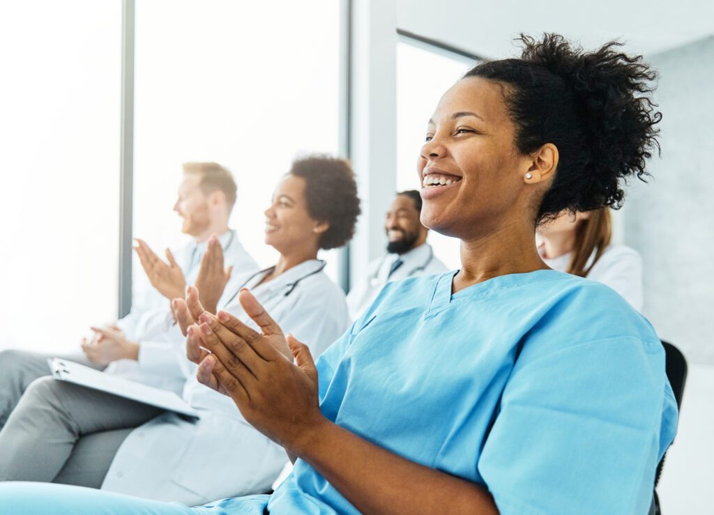 Group of medical professionals clapping in an audience