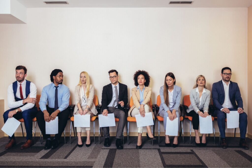 Job candidates sitting in chairs preparing for interviews