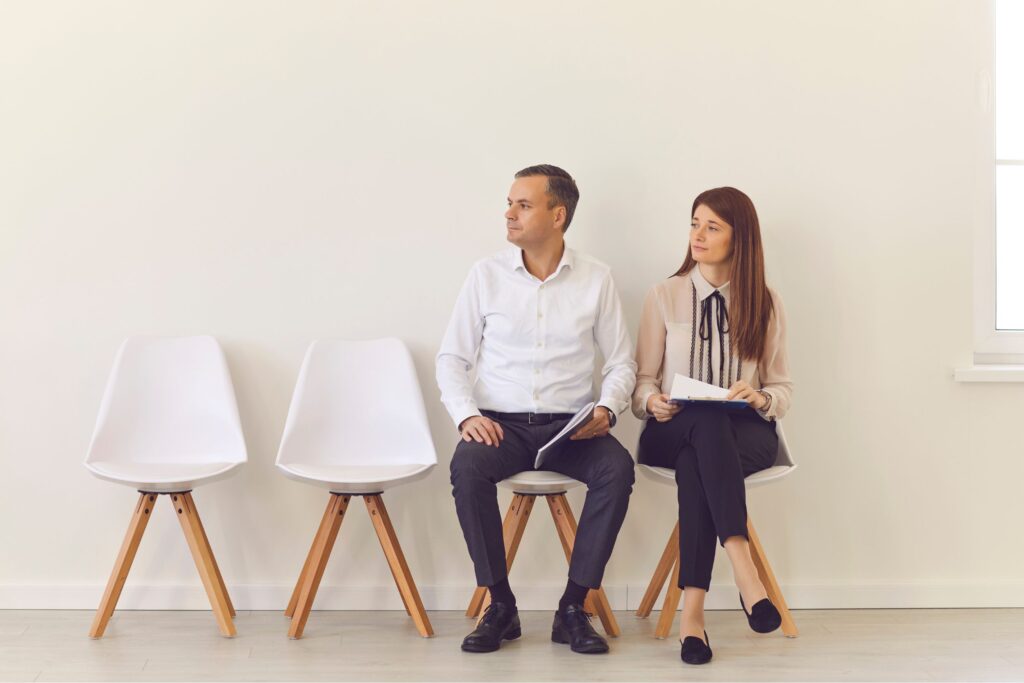 Two job candidates sitting in chairs 