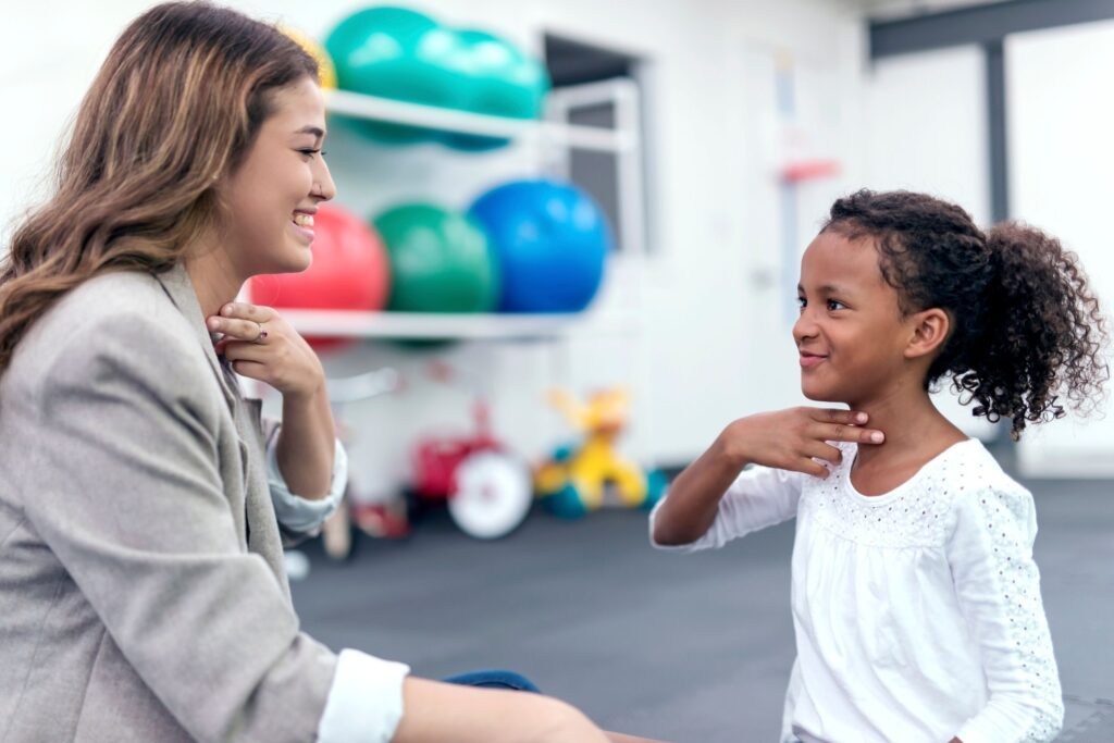 A speech therapist helping a young girl