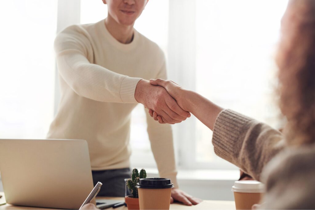 Two people shaking hands during a job interview